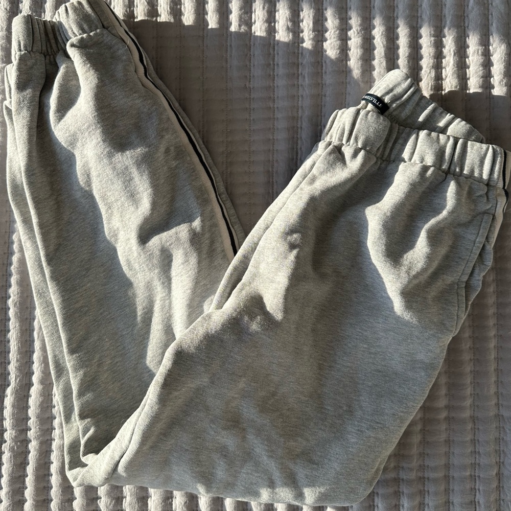 Gray sweatpants with black and white stripe detail on the sides